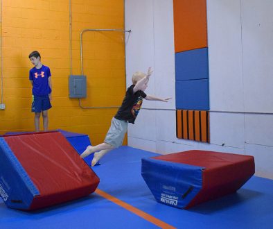 Web header Little boy making jump in obstacle course