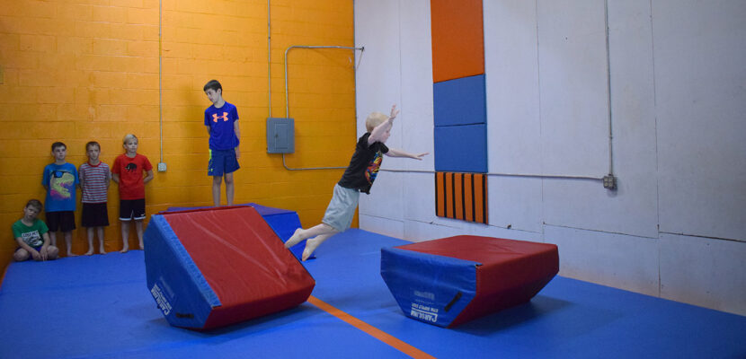 Web header Little boy making jump in obstacle course
